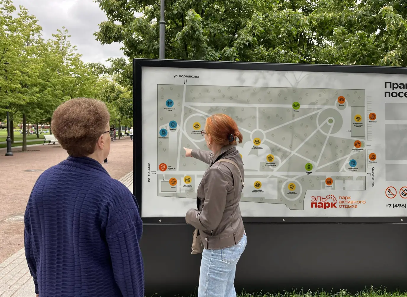 Two visitors looking at the El Park navigation map to find attractions and facilities.