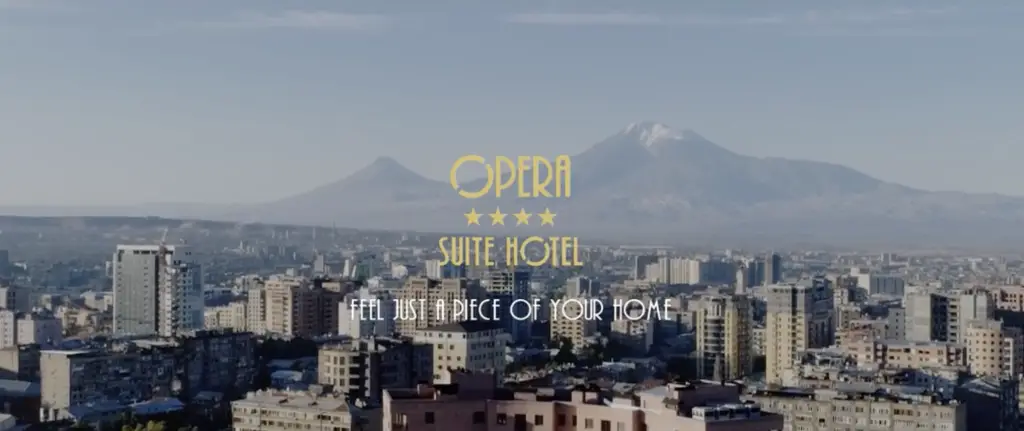 Panoramic view of Yerevan city skyline with Mount Ararat in the background, Opera Suite Hotel logo and slogan ‘Feel just a piece of your home’ overlaid.