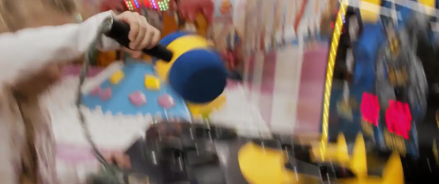 Child playing a hammer arcade game at Chudo-Park family entertainment center.