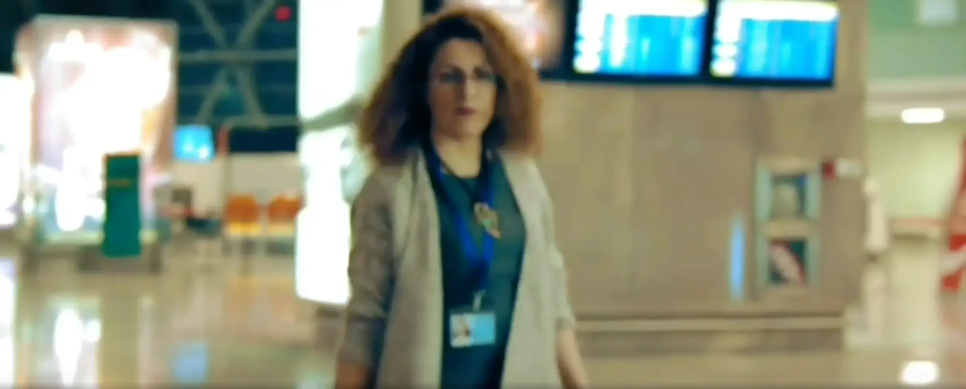 Armine Tumanyan walking through an airport terminal, featured in SHACLAMIAN’s personal branding film highlighting her work as an art manager, curator, and painter.