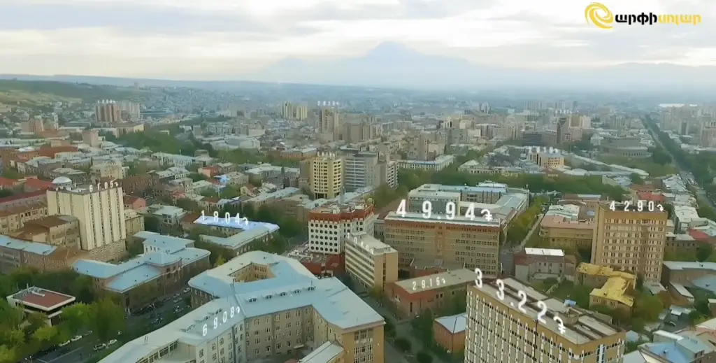 Aerial view of Yerevan city with Mount Ararat in the background, overlaid with floating digital numbers symbolizing solar energy generation data.